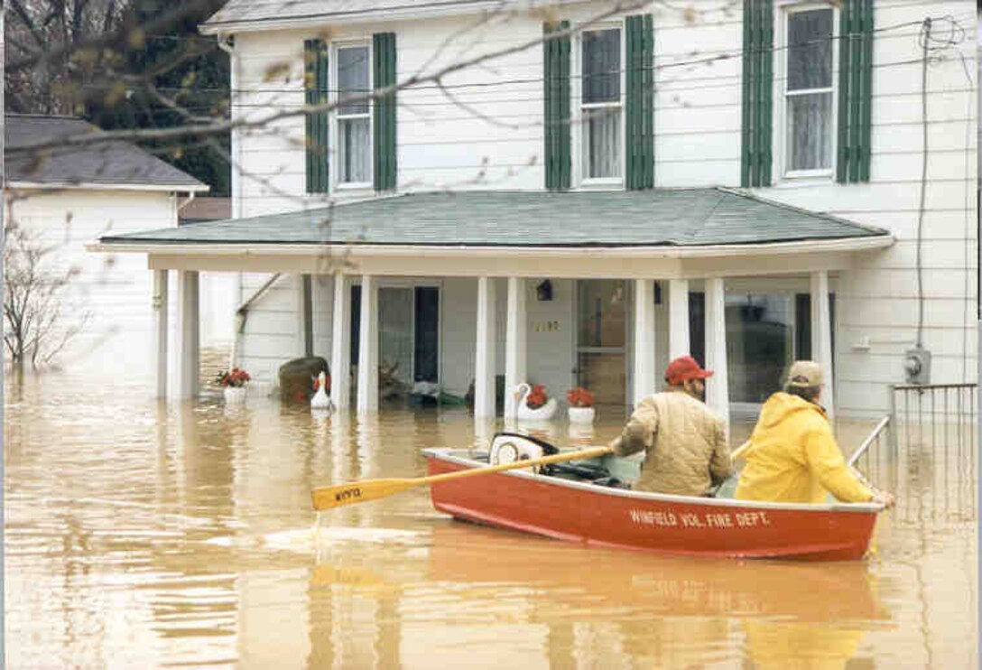 Men Paddle Through Flooded Streets
