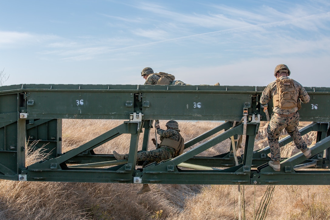U.S. Marines with Bridge Company, 7th Engineer Support Battalion, build a medium-girder bridge.