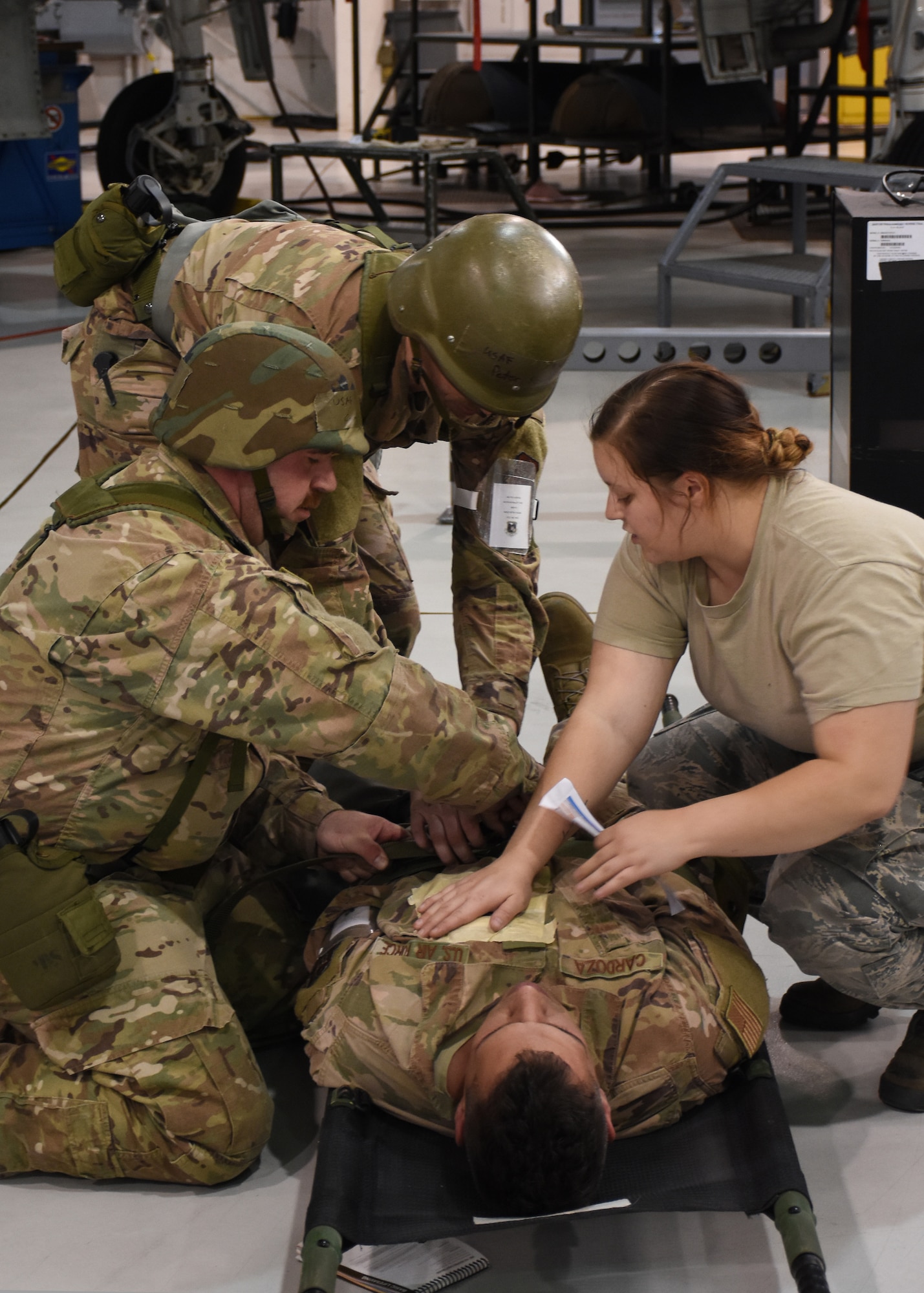 Airmen with the 442d Maintenance Squadron provide self-aid buddy care to a simulated-wounded wingman during a wing-level exercise, Ozark Thunder 20-01, at Whiteman Air Force Base, Mo., Nov. 3, 2019. The exercise is meant to test the wing’s ability to survive and operate and perform mission essential tasks during contingency operations.