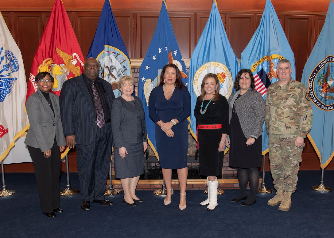 Five women and two men pose in front of flags at the McNamara Headquarters Complex Nov. 20 National American Indian and Alaska Native Heritage Month observance.
