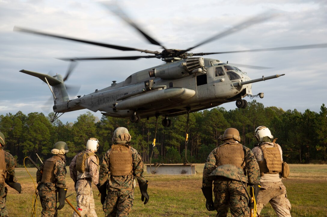 U.S. Marines with the Basic Landing Support Specialist Course, Logistics Operations School, Marine Corps Combat Service Support Schools, move away after attaching a beam to a CH-53E Super Stallion during a helicopter support team training exercise at the Condor range on Camp Lejeune, N.C., Nov. 5, 2019. HST missions consist of hooking external loads of gear and supplies to aircraft, allowing them to deliver and recover them quickly and efficiently. (U.S. Marine Corps photo by Lance Cpl. Taylor Smith)