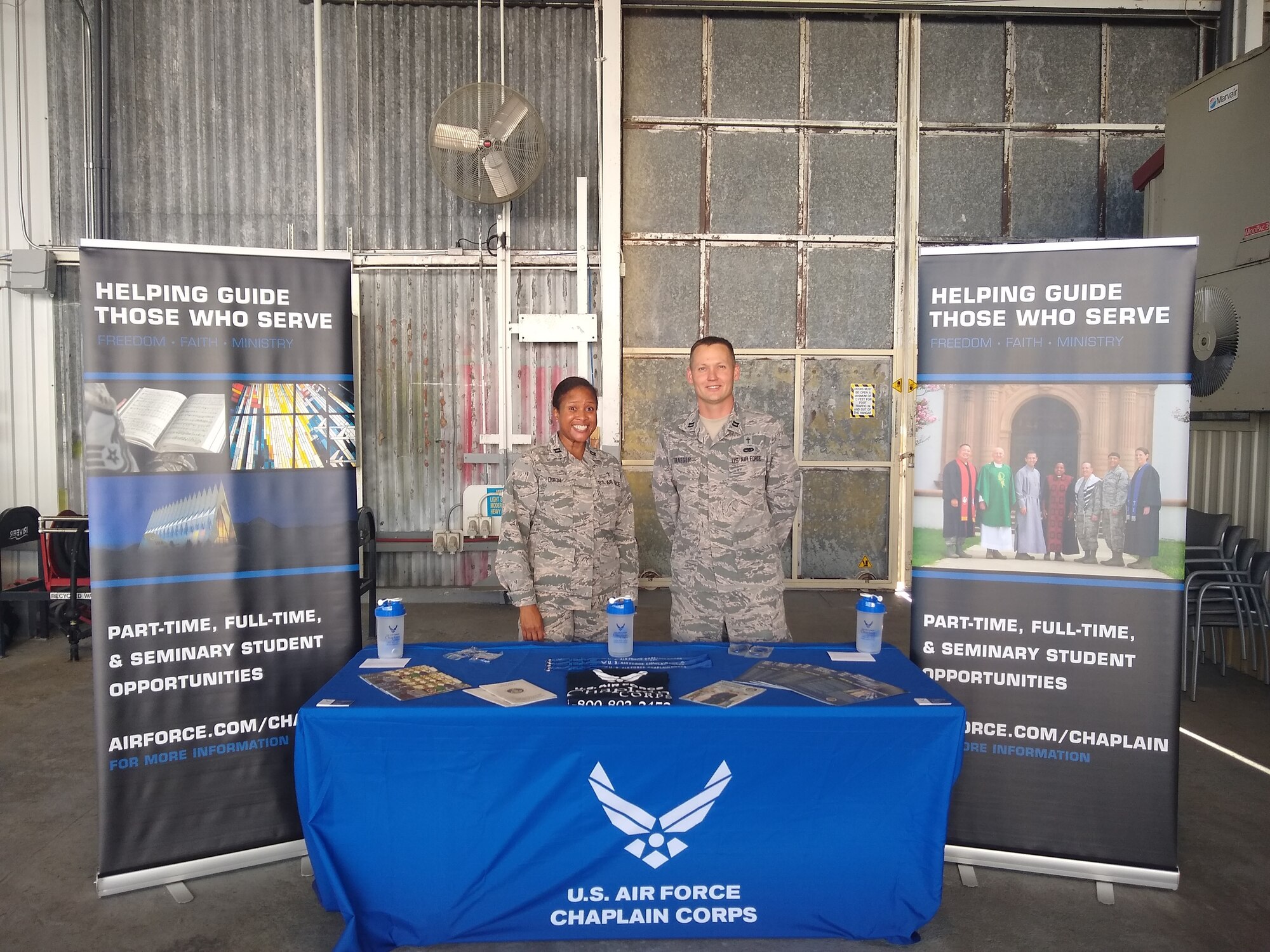 Capts.Tara Dixon and Mark Traeger, Air Force Recruiting Service staff chaplains, man a recruiting booth set up for their career field during an Air Force civic leader tour of Joint Base San Antonio-Randolph, Texas, on Nov. 6, 2019.