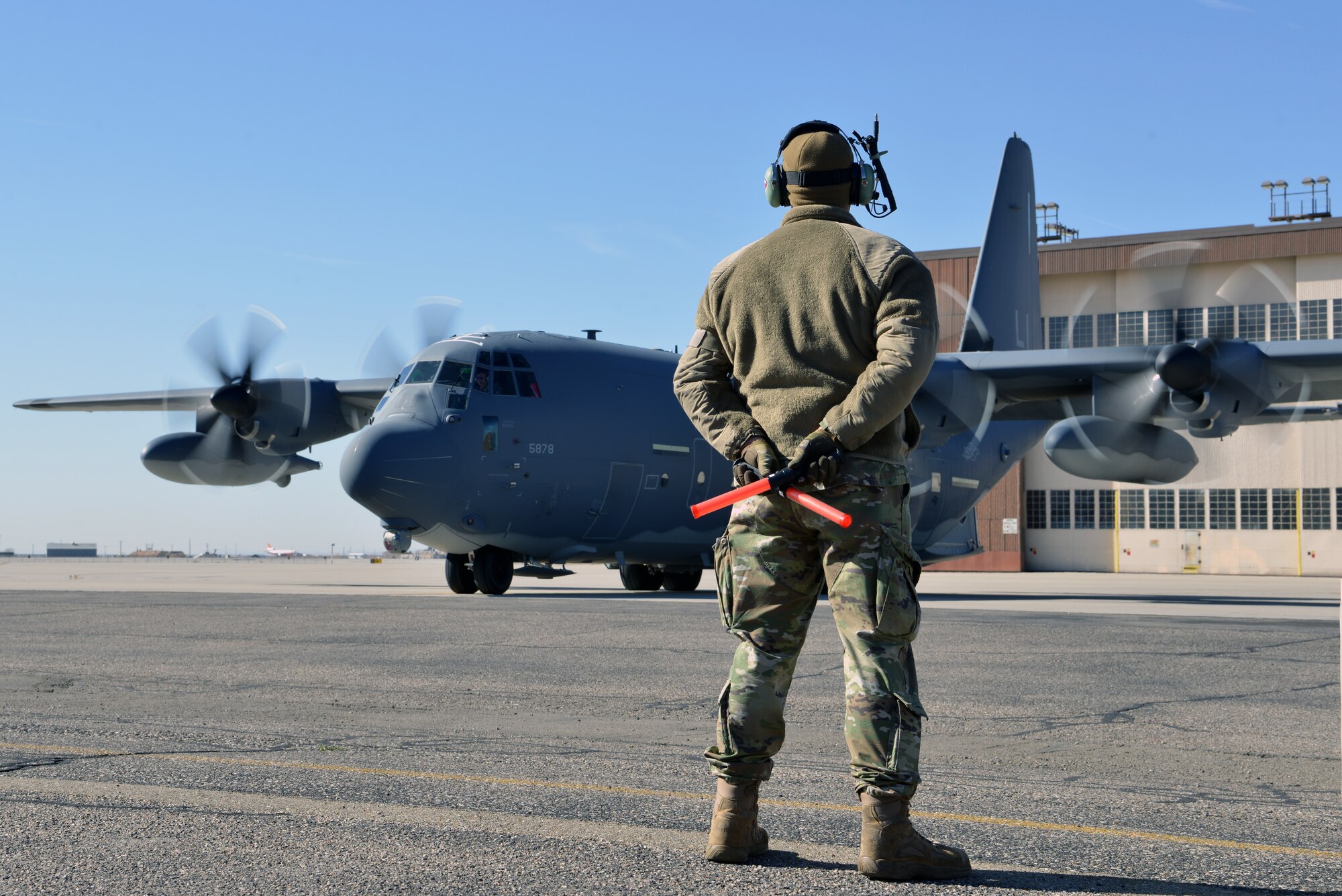 U.S. Air Force Airman 1st Class Paul Hinkle, 415th Aircraft Maintenance Unit crew chief, waits for the pilots of a MC-130J Commando II to complete preflight checks on the flight line at Kirtland Air Force Base, N.M., Nov. 14, 2019.  The 415th AMU is responsible for all maintenance on the MC-130J Commando II and HC-130J Combat King II aircraft assigned to keep them mission ready for the 415th Special Operation Squadron. (U.S. Air Force photo by Staff Sgt. Dylan Nuckolls)
