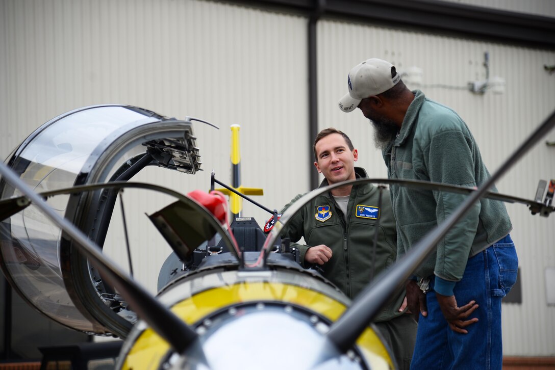 First Lt. Cody Favorite, 37th Flying Training Squadron instructor pilot, shows a retiree guest the inner workings of a T-6 Texan II, Nov. 14, 2019, on Columbus Air Force Base, Miss. The day aligned with November’s theme of military family appreciation and allowed Columbus AFB to show its gratitude for the retiree community. (U.S. Air Force photo by Airman 1st Class Jake Jacobsen)