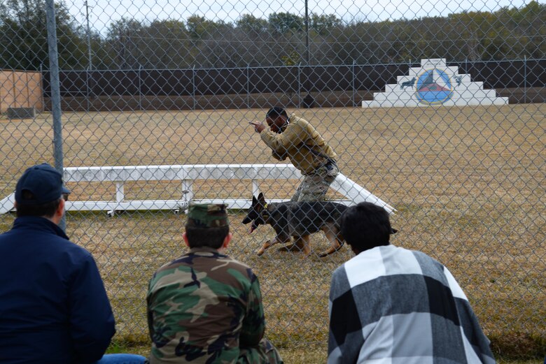 Senior Airman Anthony Story, 14th Security Forces Squadron Military Working Dog handler, shows training techniques for his working dog to Retiree Appreciation Day guests Nov. 14, 2019, on Columbus Air Force Base, Miss. The handlers shared the everyday life of an MWD to include deployed life and talked about the dogs’ roles such as tracking, search and rescue or bomb detection. (U.S. Air Force photo by Airman 1st Class Jake Jacobsen)