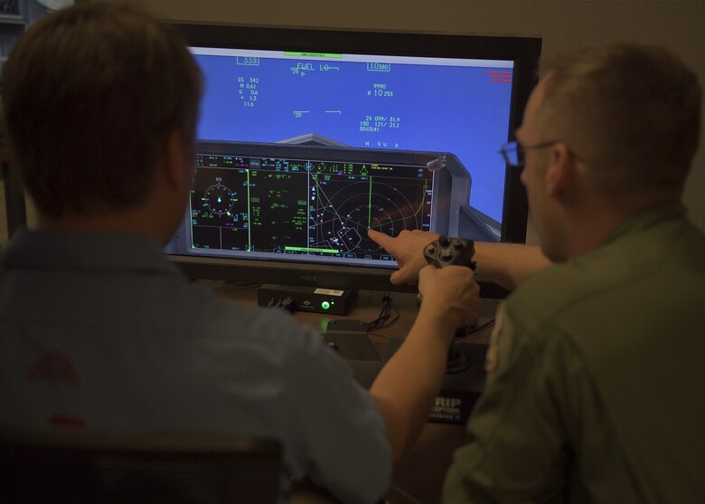 Maj. Grant Saum (right), Eielson Air Force Base 354th Fighter Wing program integration office facilitator, instructs Bobby Wilkin (left), Eielson AFB civic leader, on using an F-35A Lightning II simulator Nov. 19, 2019, at Luke AFB, Ariz.