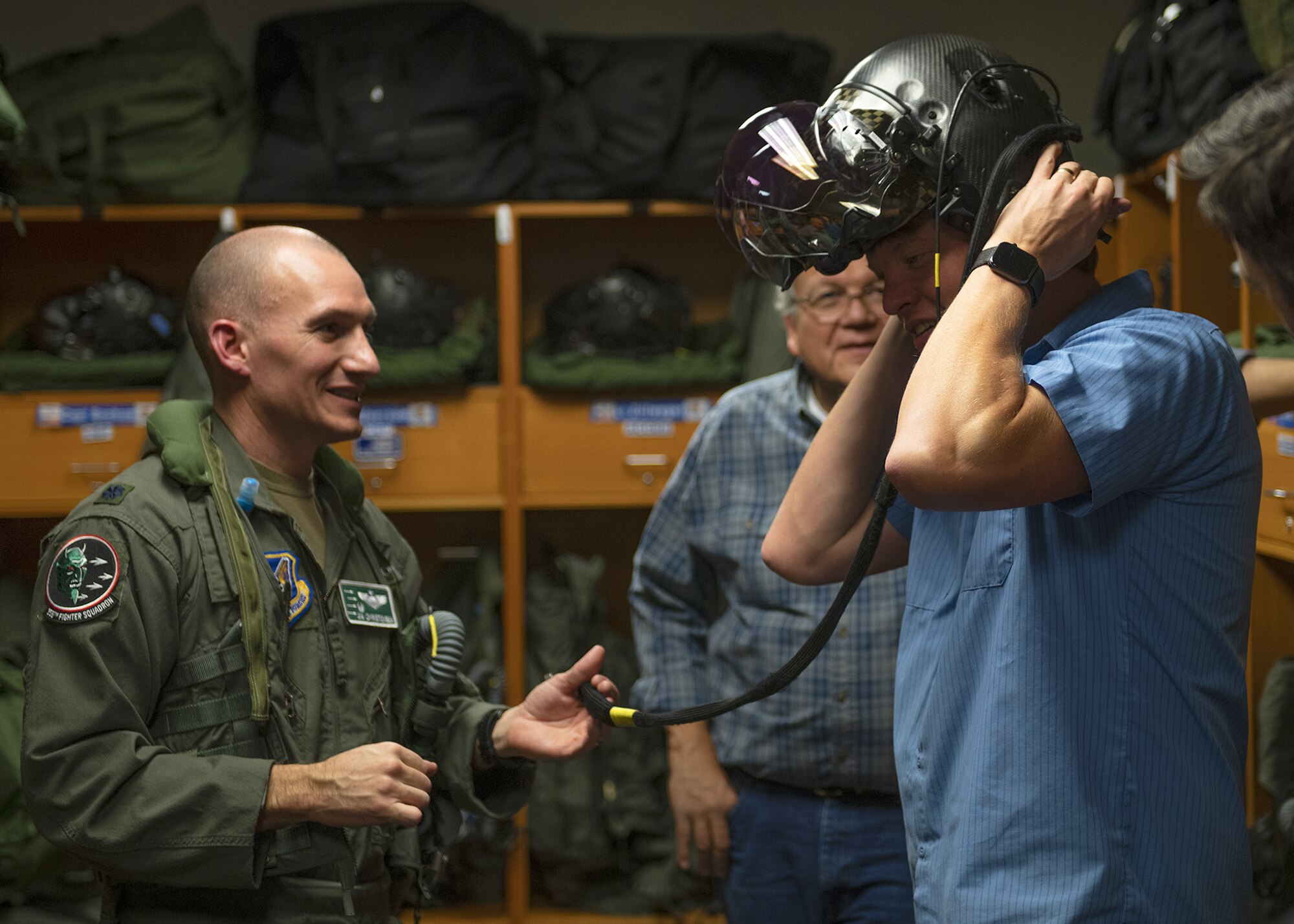 Lt. Col. James Christensen (left), Eielson Air Force Base 356th Fighter Squadron commander, who flies at Luke AFB, fits his F-35A Lightning II helmet on Bobby Wilkin (right), Eielson AFB civic leader, Nov. 19, 2019, at Luke AFB, Ariz.