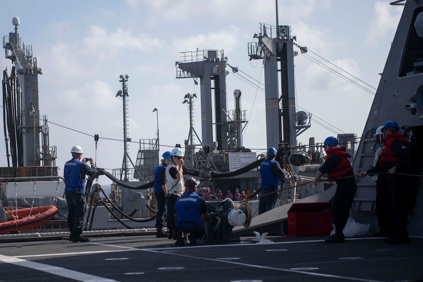 Sailors work on ship’s deck.