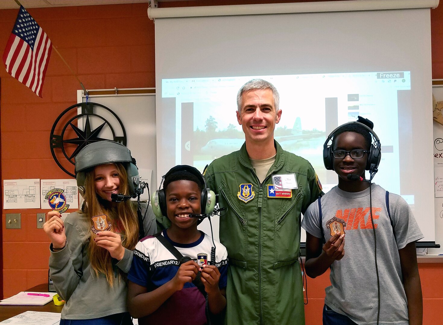 Maj. Matthew Menendez, 68th Airlift Squadron pilot, Joint Base San Antonio-Lackland, Texas, awards patches and coins to students, Casey Finn, Owen Coleman, and David Oludare at Dolph Briscoe Middle School, Nov. 11, 2019, during Northside Independent School District’s 10th annual, Veterans Day ceremony for Veterans Appreciation Day.
