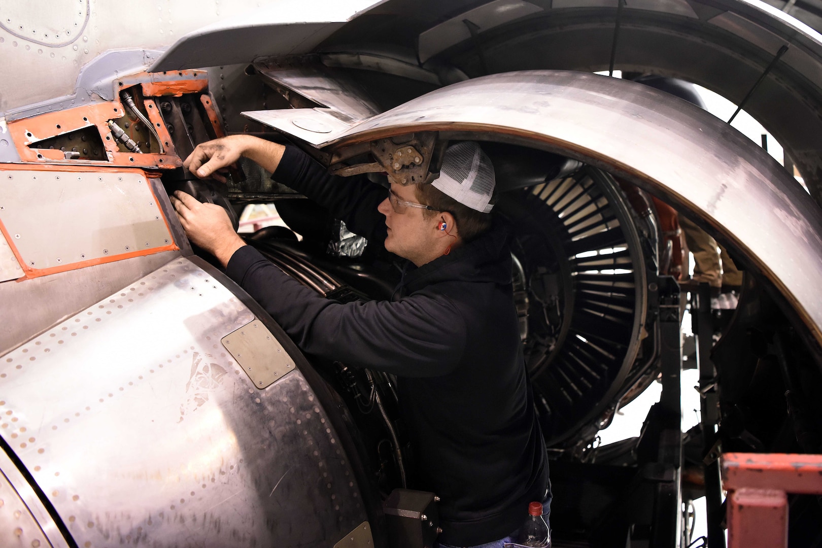A man works on the engine of an aircraft.