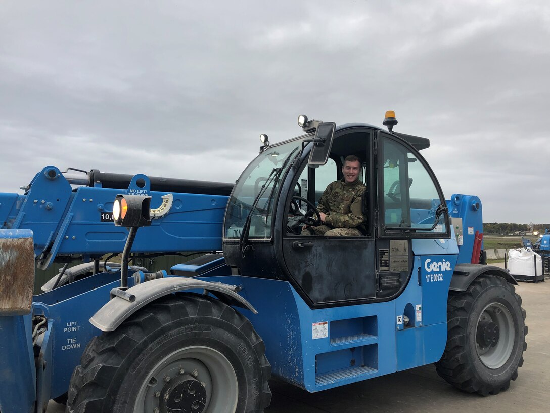 U.S. Air Force Staff Sgt. Dylan Rymer, 435th Contingency Response Squadron aerial port journeyman, takes a break while operating a telehandler during Hybrid Airman training at Ramstein Air Base, Germany, Nov. 7, 2019. A telehandler unloads rapid-setting concrete sacks from a warehouse trailer and places them in a designated location for ease-of-use. (U.S. Air Force photo by Capt. Daniel McKeown)