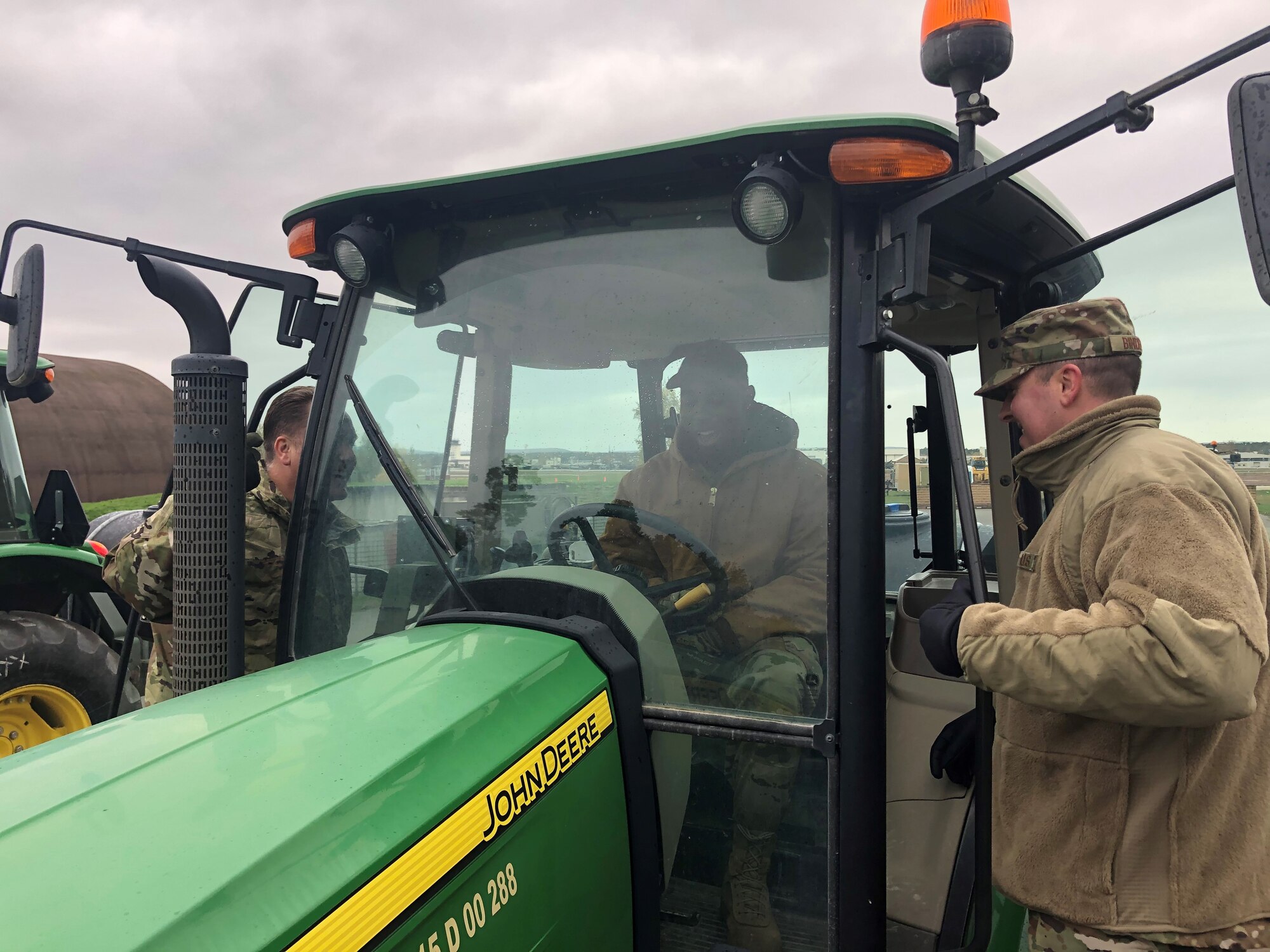 U.S. Air Force Tech. Sgt. Ernie T. Williams Jr, 435th Construction and Training Squadron electrical contingency instructor, shows Master Sgts. James Bindert and Daniel Williams from the 435th Contingency Response Support Squadron how to operate a John Deere tractor with kick broom attachment at Ramstein Air Base, Germany, Nov. 7, 2019. The John Deere with kick broom is used to remove foreign object debris during Rapid Airfield Damage Repair operations. (U.S. Air Force photo by Capt. Daniel McKeown)