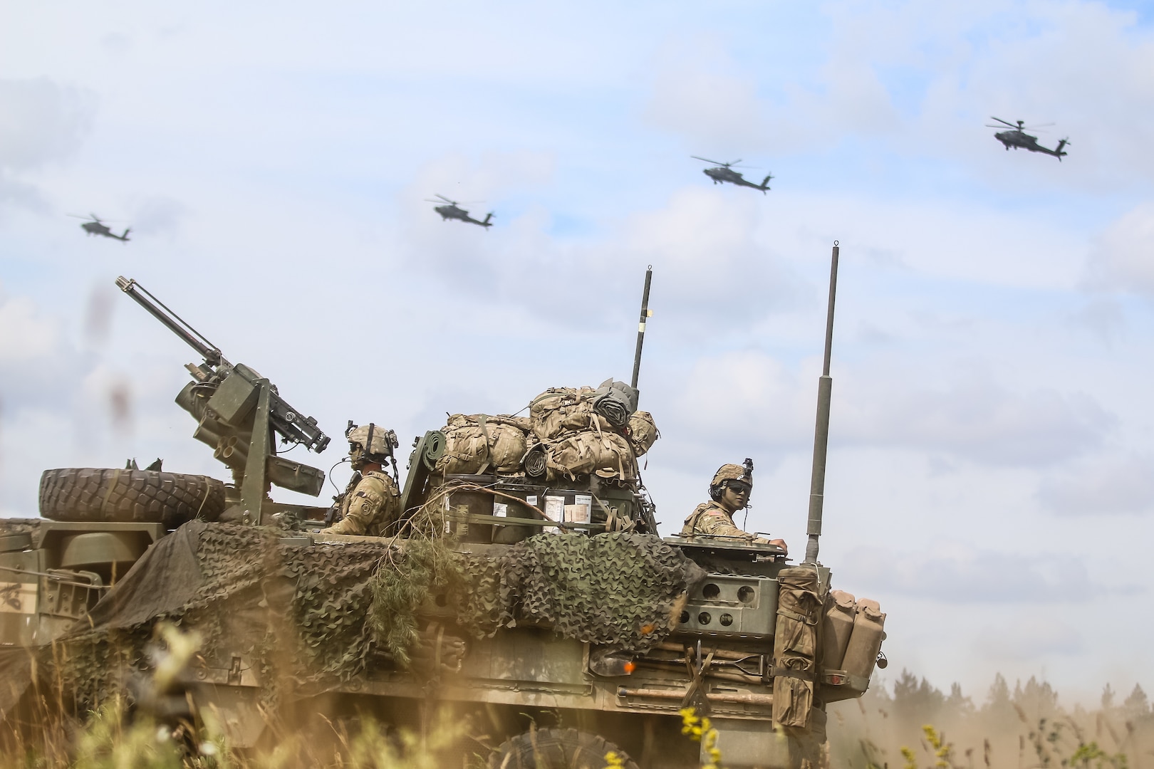 Interim Armored Vehicle “Stryker” and AH-64 Apache helicopters with Battle Group Poland move to secure area during lethality demonstration at Bemowo Piskie Training Area, Poland, June 15, 2018, as part of Saber Strike 18 (U.S. Army/Hubert D. Delany)