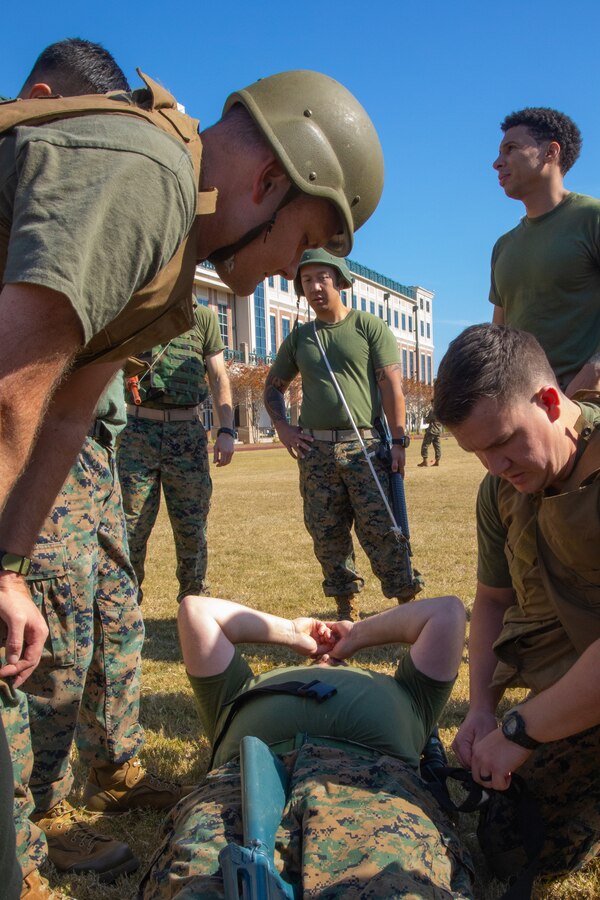 Navy Corpsmen undertaking a Tactical Combat Casualty Care course provided by Marine Forces Reserve secure Chief Petty Officer Michael Young, playing the role of a casualty, on a stretcher simulating the tactical evacuation care section of TCCC at Marine Corps Support Facility New Orleans, Nov. 20, 2019. TCCC has been the most effective way to reduce casualties from injuries on the battlefield since 1996 due to its ability to address immediate threats to life and decrease the amount of time before surgical intervention can occur. (U.S. Marine Corps photo by Lance Cpl. Christopher W. England)