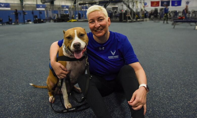 Chief Master Sgt. Nicole Johnson, wounded warrior, poses for a portrait with her service dog, Turley, during a running scrimmage for Northeast Warrior CARE Week on Joint Base Andrews, Md., Nov. 13, 2018. Johnson joined the program to help fight her battle with post-traumatic stress disorder from a military sexual trauma incident. She initially wanted a dog just as a companion she said, but feels like Turley picked her. “I needed something to feel a little safer at home,” Johnson said. “It turns out, she picked out the perfect human. She provides everything I need in safety, mobility and emotional support.” (U.S. Air Force photo by Airman 1st Class Michael S. Murphy)