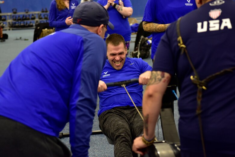 Master Sgt. Adam Boccher, Wounded Warrior athlete, rows for one minute straight against three other participants on Joint Base Andrews, Md., Nov. 14, 2018. Each member’s rowing controlled a small game piece on a projector screen so they could see who was going the furthest in the time allotted. (U.S. Air Force photo by Airman Noah Sudolcan.)