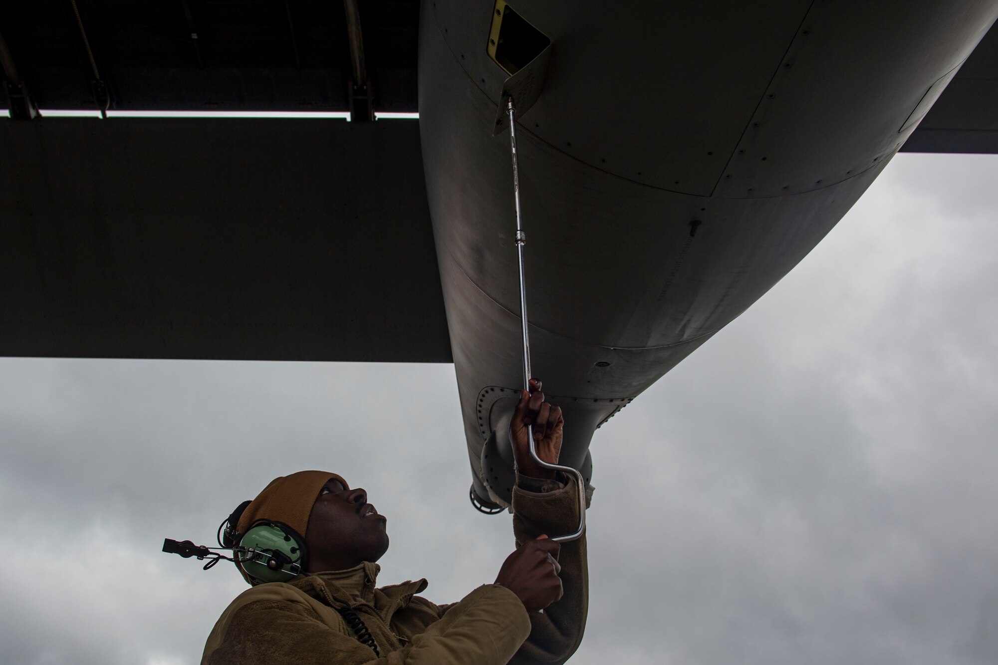 A photo of an Airman opening a compartment on an aircraft.