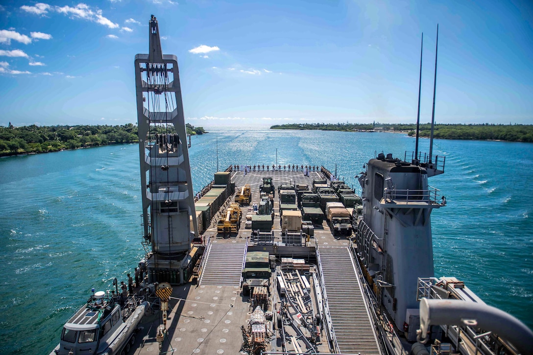 Sailors and Marines stand on a ship's deck.