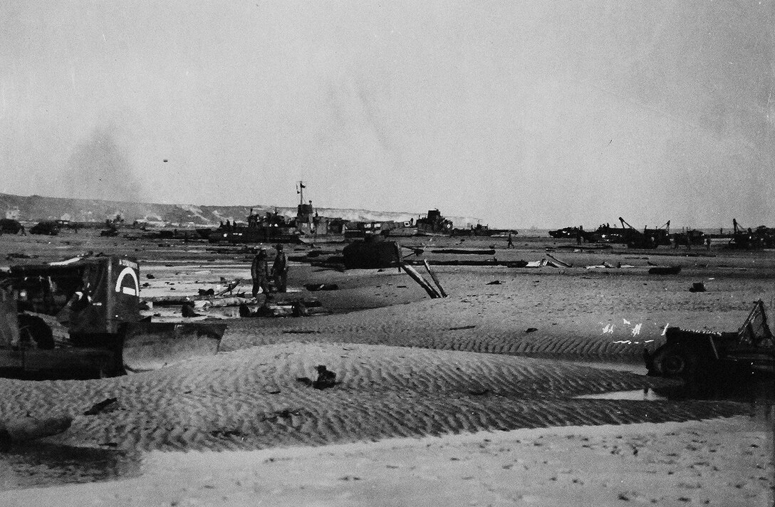 Equipment and armored vehicles, some damaged, stretch across sands in Normandy where Allies seized beachhead, June 6, 1944 (Courtesy AP Photo)