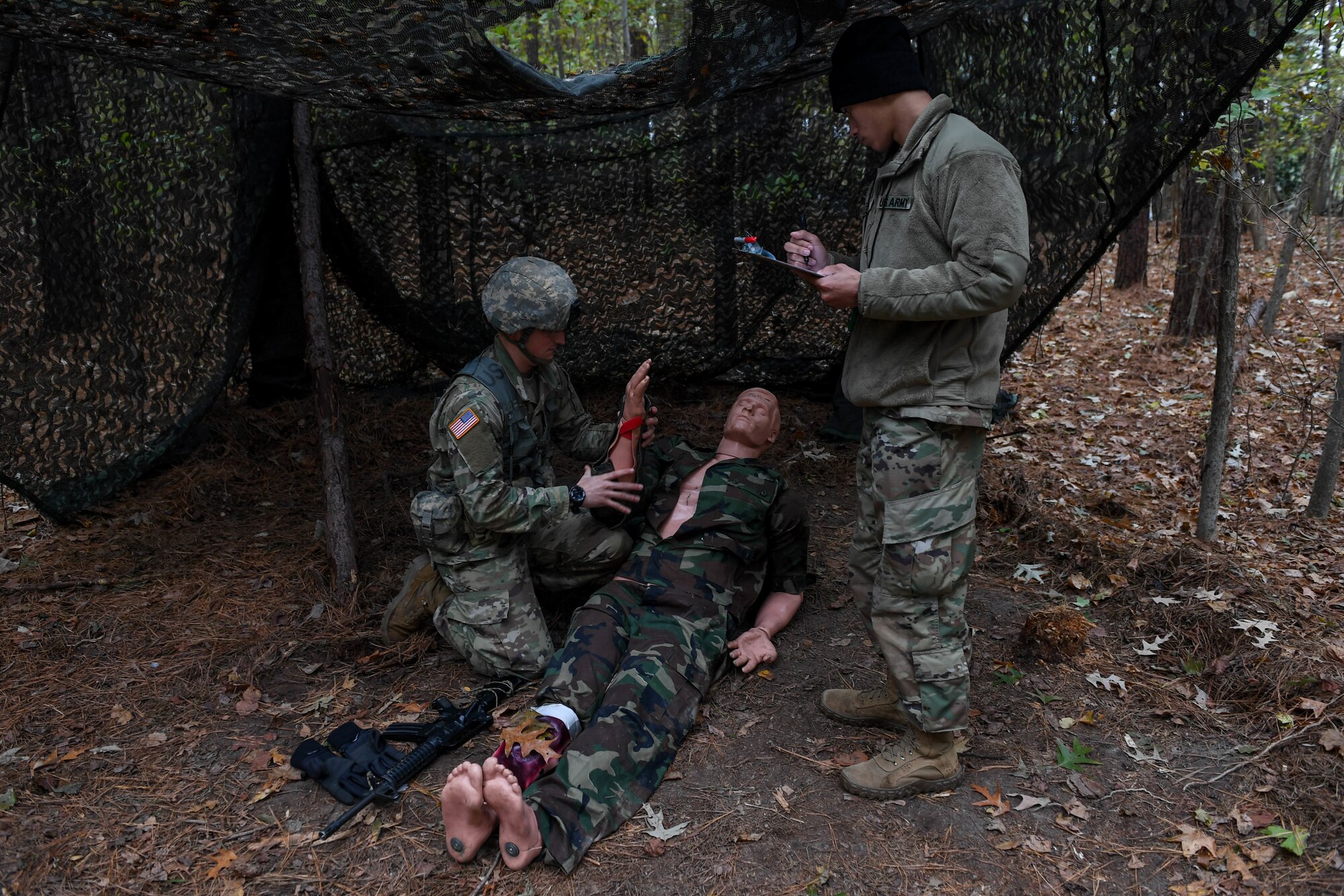 U.S. Army Staff Sgt. Edward Chase, a drill sergeant with the 2-39 Infantry Battalion, 165th Inf. Brigade at Fort Jackson, dresses a broken bone injury during the Expert Soldier Badge course at Joint Base Langley-Eustis, Virginia, Nov. 18, 2019. The ESB consists of the Army Physical Fitness Test, day and night land navigation, medical, weapons and patrol lanes and concluded with a 12-mile foot march. (U.S. Air Force photo by Senior Airman Derek Seifert)