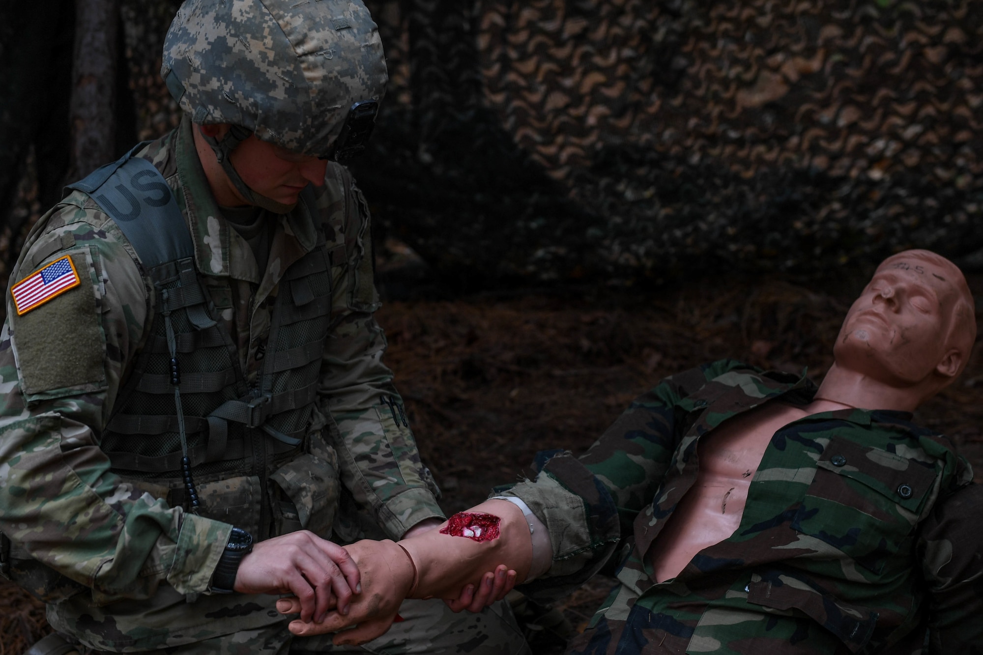 U.S. Army Staff Sgt. Edward Chase, a drill sergeant with the 2-39 Infantry Battalion, 165th Inf. Brigade at Fort Jackson, examines a wound during the medical lane of the Expert Soldier Badge course at Joint Base Langley-Eustis, Virginia, Nov. 18, 2019. There were 10 tasks in the medical lane, including requesting medical evacuation, providing care under fire, moving a casualty and controlling blood loss.  (U.S. Air Force photo by Senior Airman Derek Seifert)