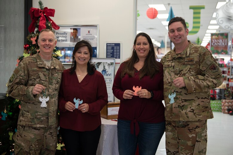 A photo of 347th Rescue Group leadership posing with their spouses during a donation event.