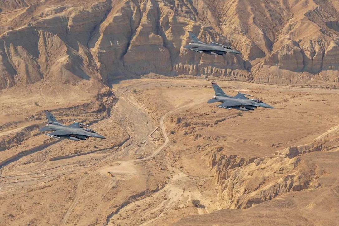 Planes fly over a desert.