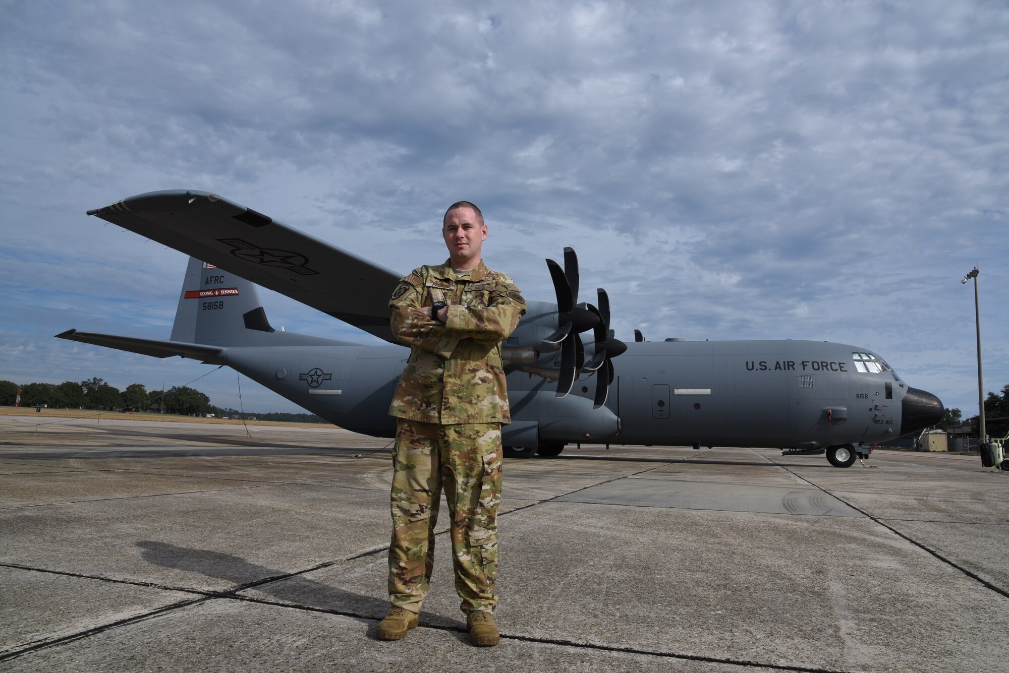 Tech. Sgt. Jonathan Parker, 815th Airlift Squadron instructor loadmaster, poses with an 815th AS, Flying Jennies, C-130J Super Hercules at Keesler Air Force Base, Miss. (U.S. Air Force photo by Jessica L. Kendziorek)