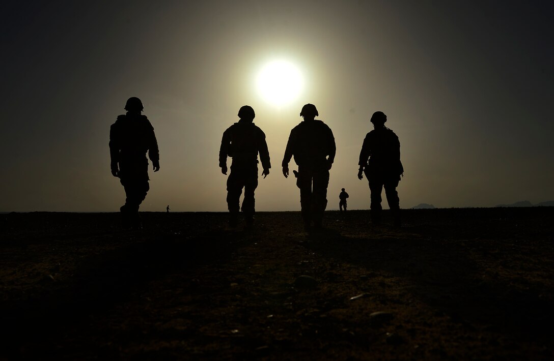 Explosive ordnance disposal technicians assigned to 466th Air Expeditionary Squadron walk toward blast pit after detonating four 500-pound bombs during demolition day, March 16, 2014 (U.S. Air Force/Vernon Young, Jr.)