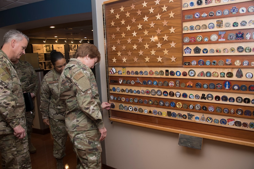 Lt. Gen. Hogg adds challenge coin to a visitor board