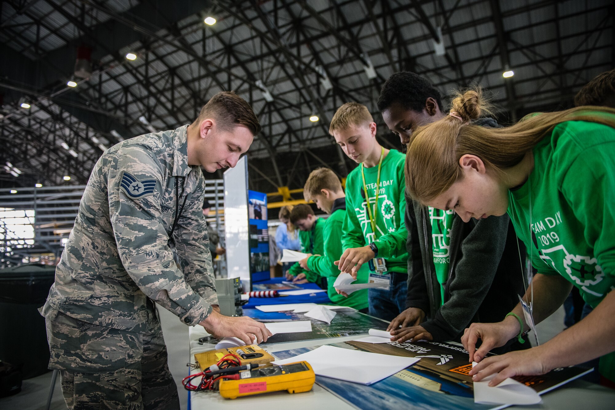 Staff Sgt. Robert Gentry, 932nd Airlift Wing Maintenance Squadron technician, speaks with students about maintenance careers within the Air Force Reserve and challenges students to create and fly paper airplanes during STEAM Day at Scott Air Force Base, Illinois, Nov. 20, 2019. The day inspires kids to explore and pursue their interests in Science, Technology, Engineering, Art and Math.  (U.S. Air Force photo by Christopher Parr)