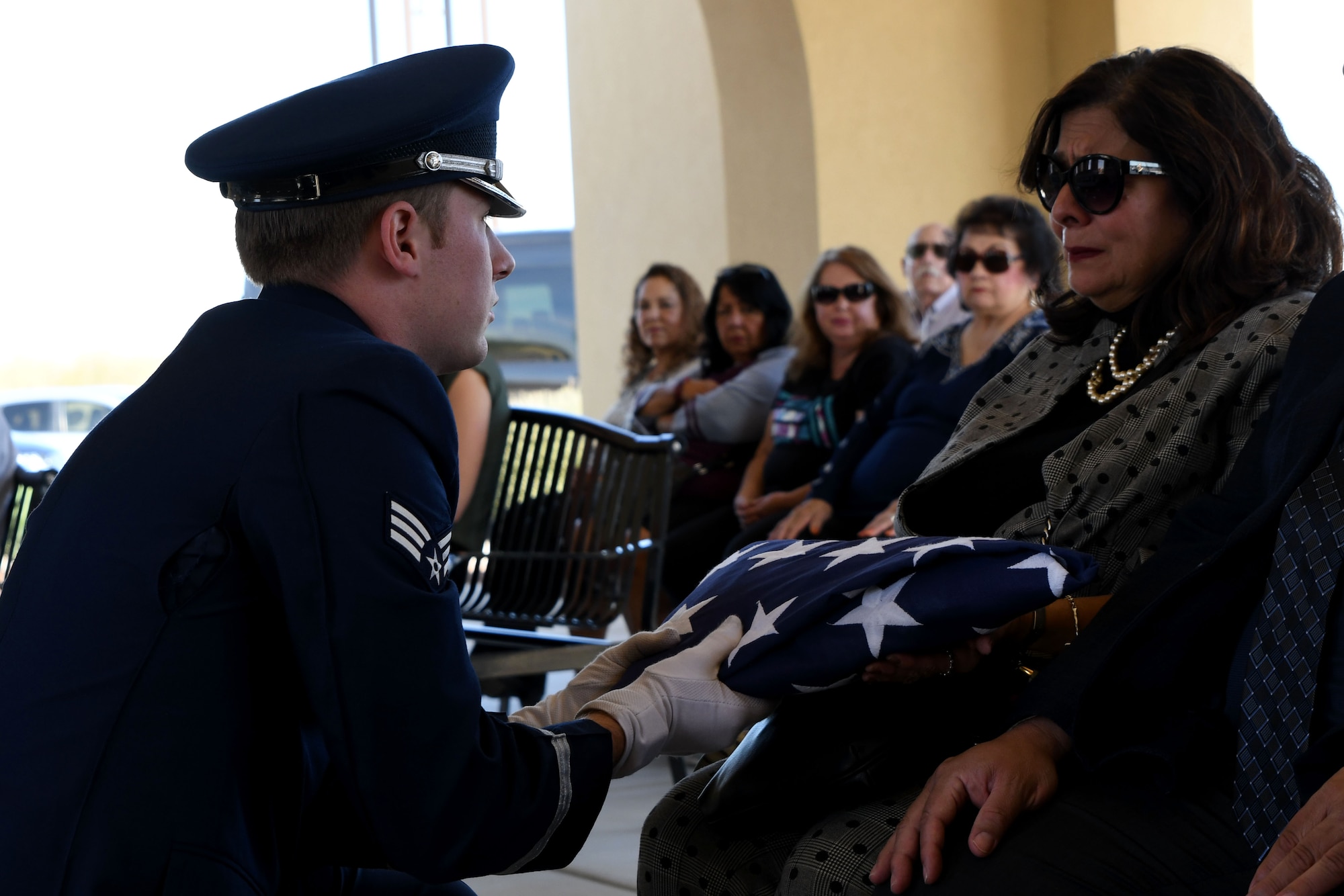 a photo of DM Base Honor Guardsman handing off the U.S. flag to the next-of-kin