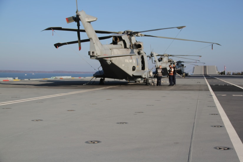Three helicopters line up on ship.