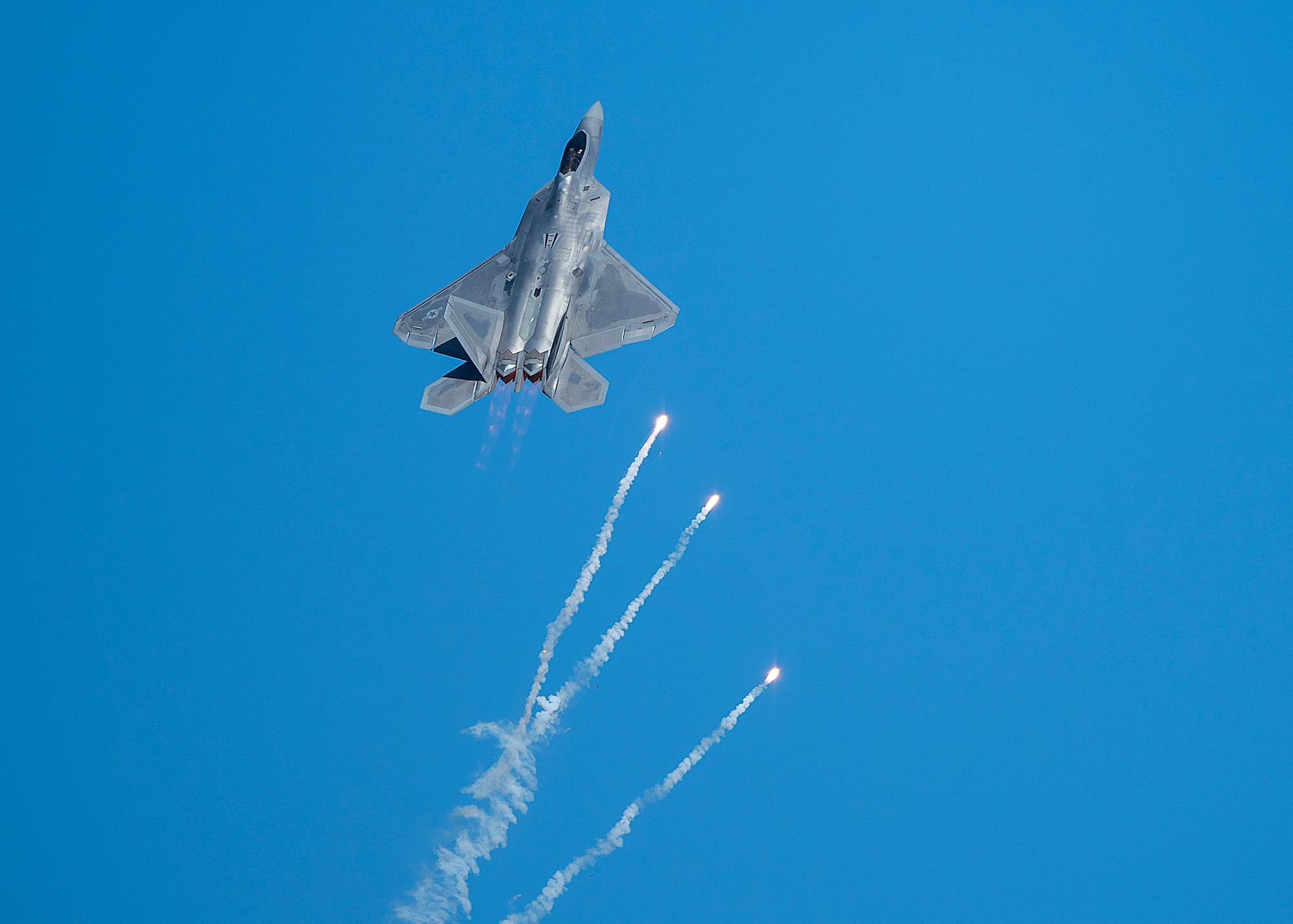 An F-22 Raptor fighter jet pops flares during air show