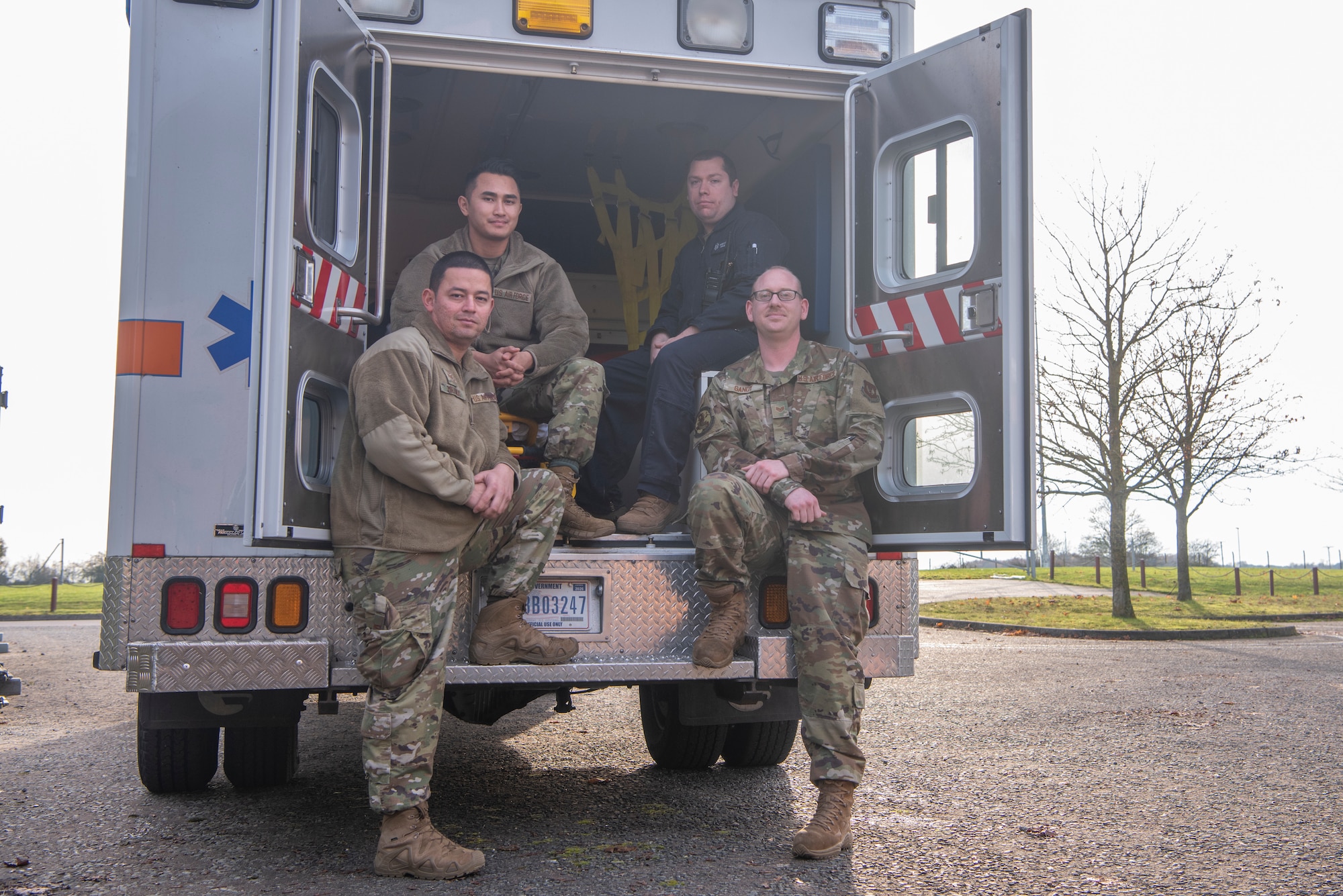 Medical personnel from the Aerospace Medicine Clinic pose for a photo on an ambulance Nov. 19, 2019, at RAF Mildenhall, England. The clinic ensures flyers are medically cleared to perform their duties while in the air. (U.S. Air Force photo by Airman 1st Class Joseph Barron)