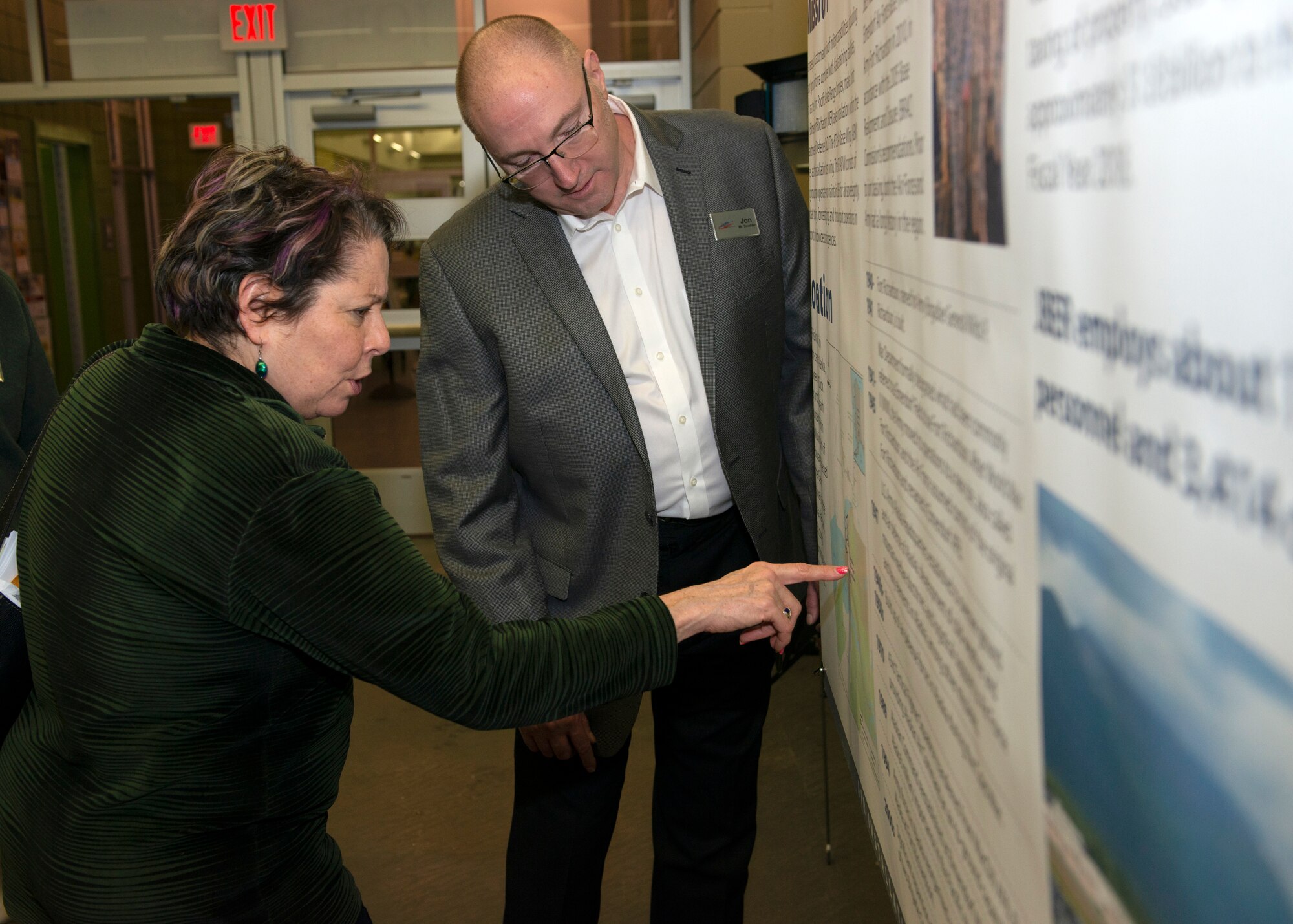 Audrey Lewis, 673d Air Base Wing Judge Advocate chief of labor law, and Jon Scudder, 673d Civil Engineer Squadron installation mission sustainment team manager, look at a poster during an Air Installation Compatible Use Zone study open house in Anchorage, Alaska, Nov. 20, 2019. Joint Base Elmendorf-Richardson, Alaska, hosted the event, which showed the results of the study, to promote transparency between the installation and its community partners.