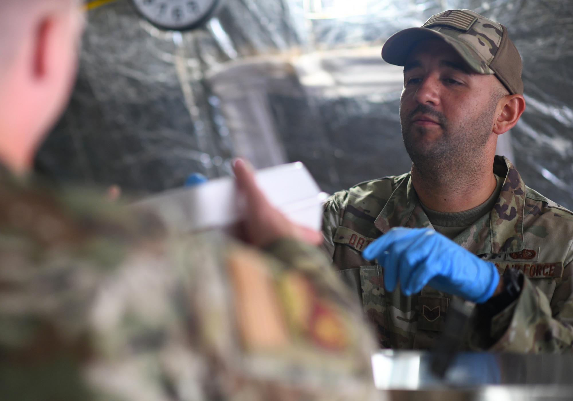 U.S. Air Force Staff Sgt. Carlos Ortega, 776th Expeditionary Air Base Squadron Services NCO in-charge of food and beverages, serves food to dining facility patrons at Chabelley Airfield, Djibouti, Nov. 13, 2109. The services Airmen receive, inspect, prepare and serve roughly 800 meals each day to Airmen, Soldiers and contractors fulfilling their duties on the airfield. (U.S. Air Force photo by Staff Sgt. Alex Fox Echols III)