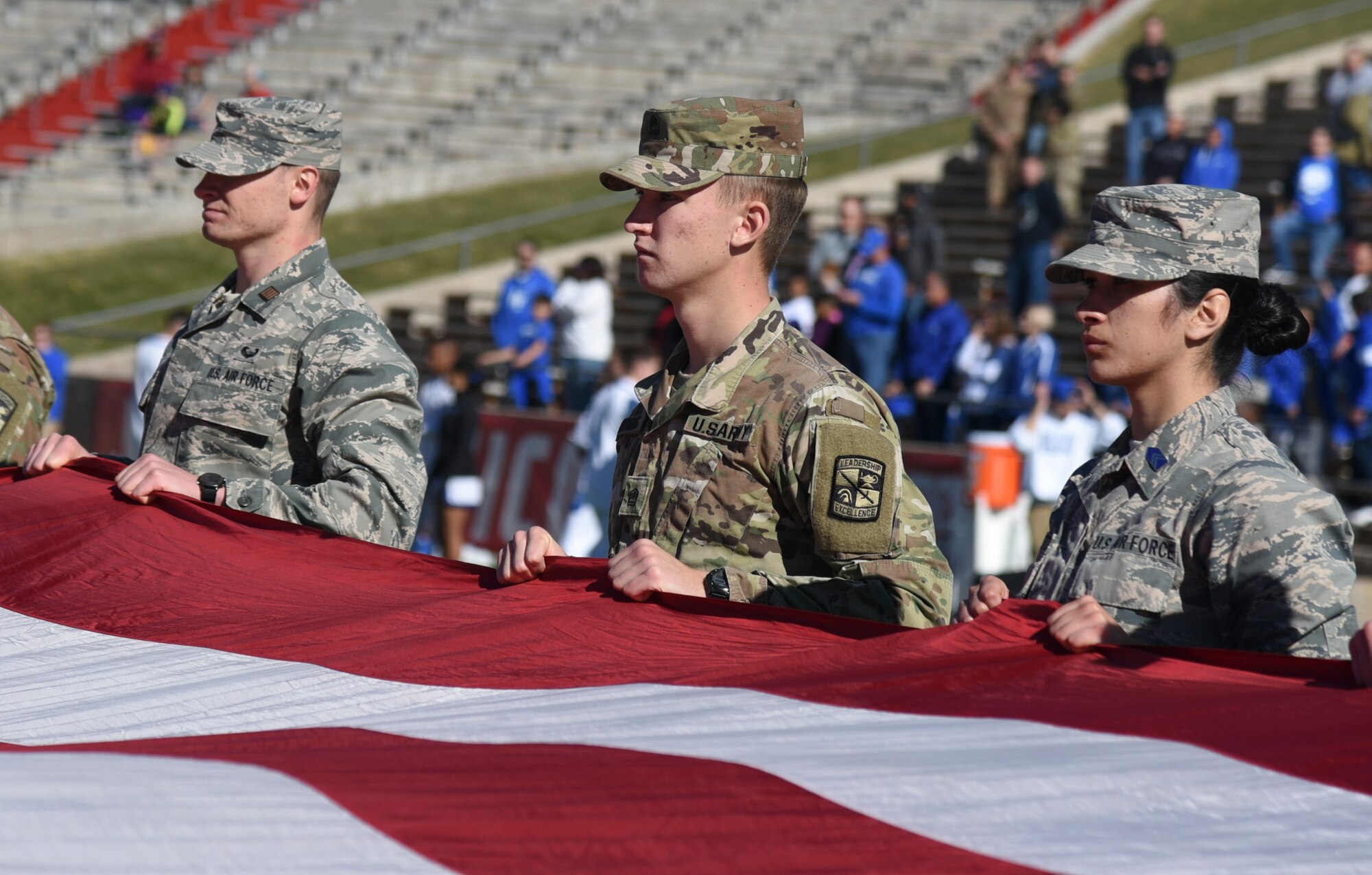 Photo of ROTC cadets holding large american flag