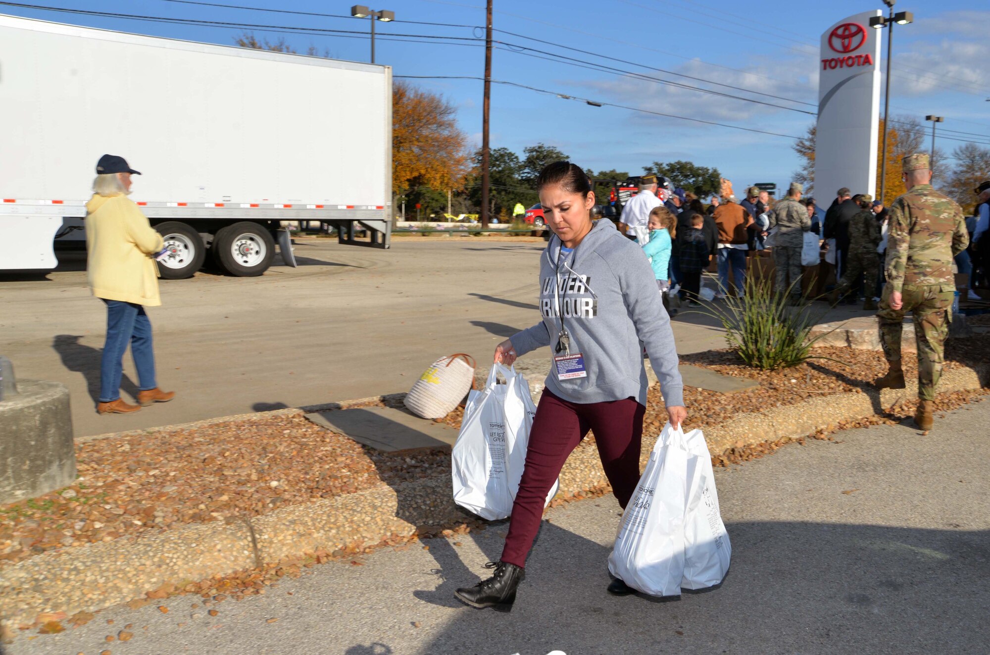 Senior Airman Michelle Quinterro, 433rd Airlift Wing staff, carries frozen turkeys to a line of cars at the ninth annual Turkeys for Troops event at Toyota of Boerne Nov. 22, 2019, in Boerne, Texas. (U.S. Air Force photo by Master Sgt. Kristian Carter)