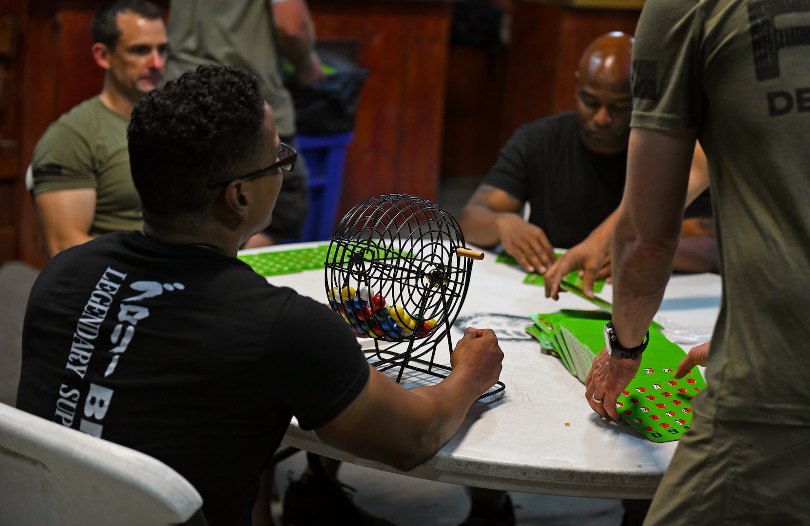 U.S. Air Force Tech. Sgt. Juan Serrano, 776th Expeditionary Air Base Squadron Services assistant manager, facilitates a bingo tournament during a Spartan Shindig at Camp Lemonnier, Djibouti, Nov. 18, 2109. The services Airmen gear monthly squadron events like these toward bringing the entire team together in a setting where members can relax, socialize and escape their demanding workload for a little while. (U.S. Air Force photo by Staff Sgt. Alex Fox Echols III)