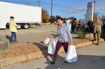 Senior Airman Michelle Quinterro, 433rd Airlift Wing staff, carries frozen turkeys to a line of cars at the ninth annual Turkeys for Troops event at Toyota of Boerne Nov. 22, 2019, in Boerne, Texas. (U.S. Air Force photo by Master Sgt. Kristian Carter)