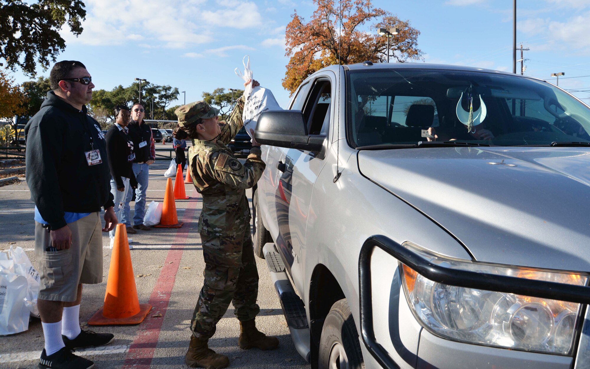 Maj. Jaime Barker, 433rd Civil Engineer Squadron commander, JBSA-Lackland Texas hands a turkey to a military family at the ninth annual Turkeys for Troops event at Toyota of Boerne Nov. 22, 2019 in Boerne, Texas. Nearly 8000 turkeys were given away to military members, veterans, and military families. (U.S. Air Force photo by Master Sgt. Kristian Carter)