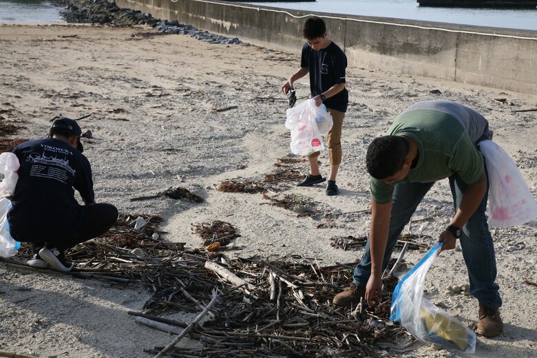 辺野古ビーチで漂着したペットボトルなどを拾う高校生と海兵隊員。海洋プラスチックごみ問題について考えている全国の高校生などが１１月２４日の朝、米海兵隊基地キャンプ・シュワブを訪れ、隊員らとビーチで清掃活動をした後、定期的に沖縄のビーチで清掃活動を行っている海兵隊に感謝状を贈呈しました。