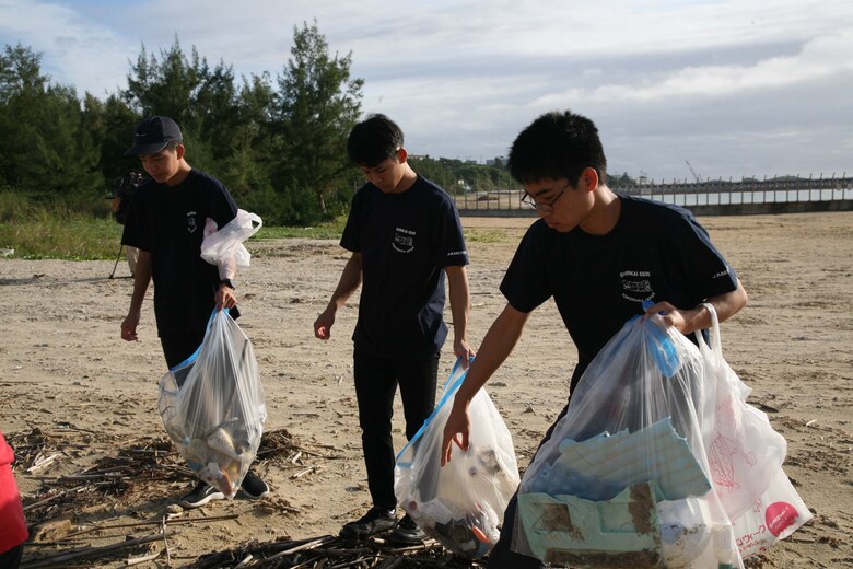辺野古ビーチで漂着したペットボトルなどを拾う高校生。海洋プラスチックごみ問題について考えている全国の高校生などが１１月２４日の朝、米海兵隊基地キャンプ・シュワブを訪れ、隊員らとビーチで清掃活動をした後、定期的に沖縄のビーチで清掃活動を行っている海兵隊に感謝状を贈呈しました。