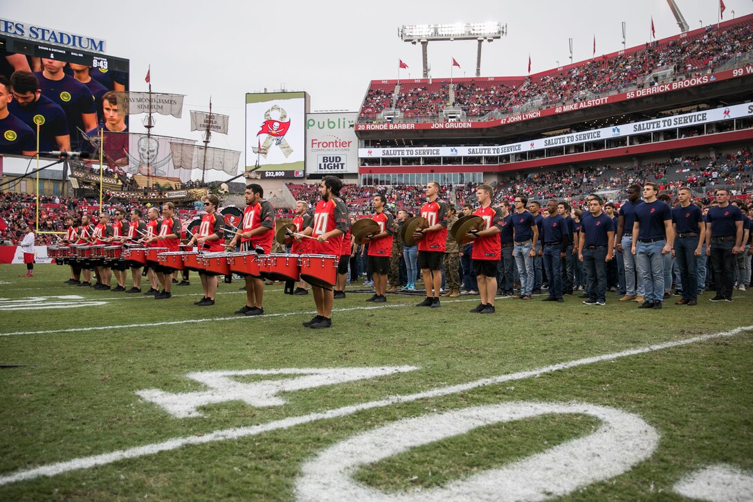 Recruits from all military service branches stand at attention during halftime of the Tampa Bay Buccaneers Salute to Service game vs. the New Orleans Saints, Nov. 17, 2019 at Raymond James Stadium. More than 180 new enlistees were read the Oath of Enlistment by U.S. Marine Corps Gen. Kenneth F. McKenzie, Jr., the commander of U.S. Central Command (U.S. Marine Corps photo by Sgt. Roderick Jacquote)