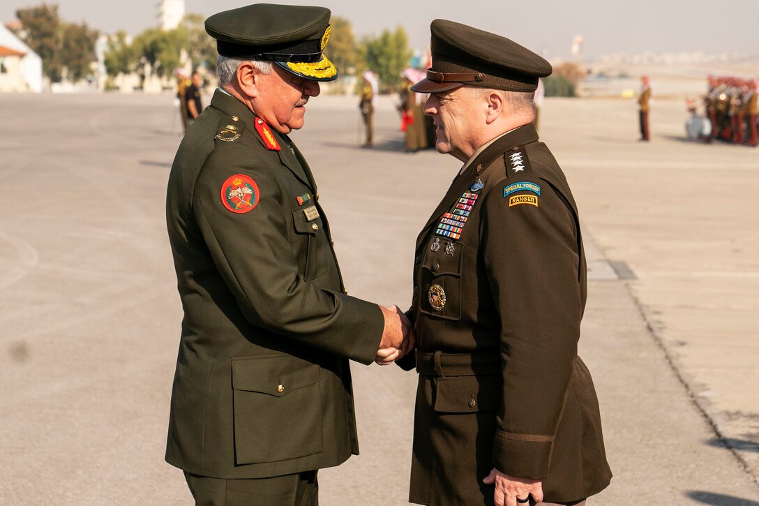 Two military leaders greet each other.