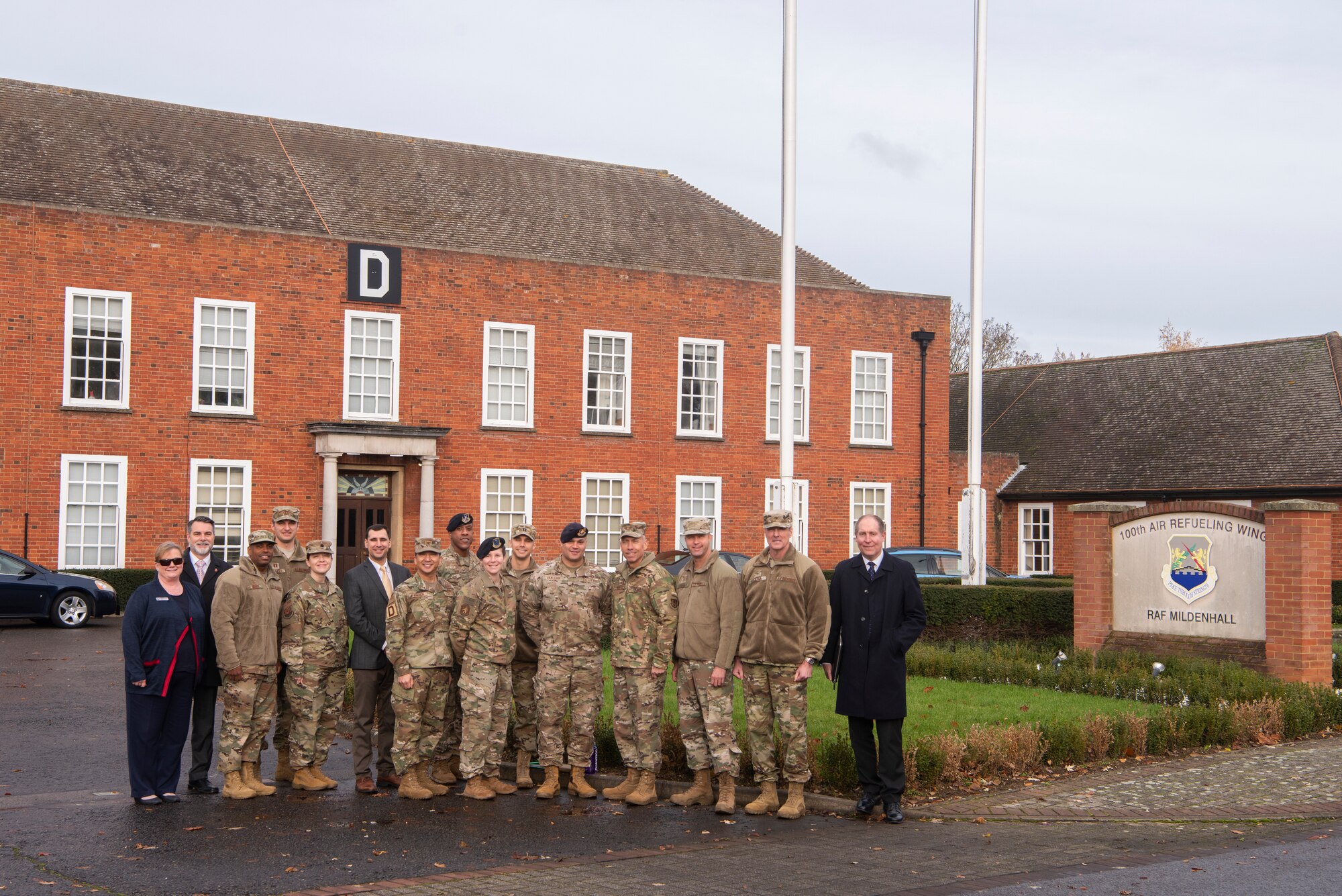 Members of the 100th Air Refueling Wing pose for a photo in front of the wing headquarters with Maj. Gen. John Wilcox, Air Force Installation and Mission Support Center commander, and Chief Master Sgt. Edwin Ludwigsen, AFIMSC command chief master sergeant, Nov. 22, 2019, at RAF Mildenhall, England. The AFIMSC provides installation and mission support that enables Team Mildenhall to complete its varied mission sets. (U.S. Air Force photo by Airman 1st Class Joseph Barron)