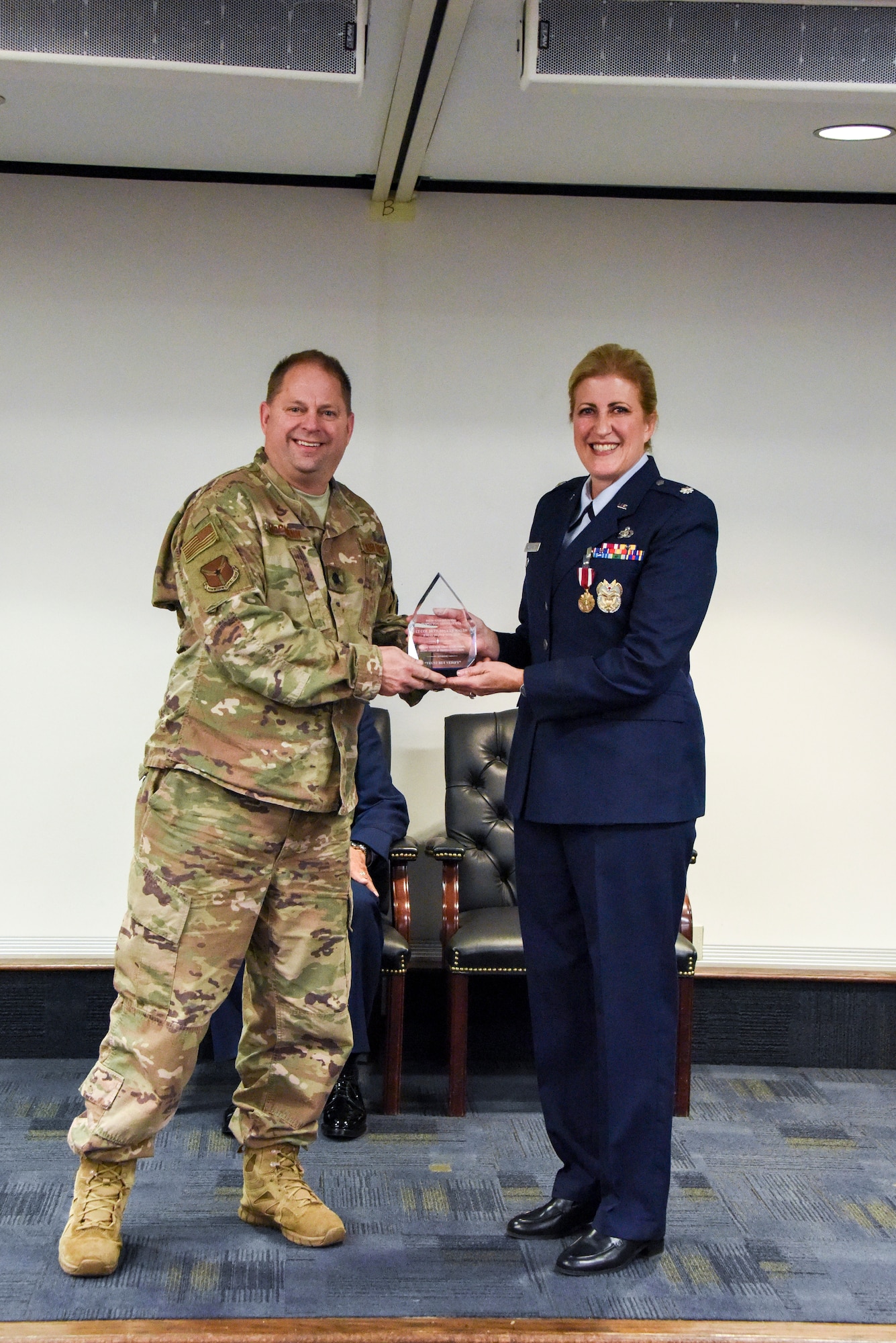 Lt. Col. Beth E. Bruker Walos, right, program administrator with the 911th Airlift Wing Inspector General inspections office, accepts a plaque from Lt. Col. Todd McCrann during her retirement ceremony at the Pittsburgh International Airport Air Reserve Station, Pennsylvania, Nov. 2, 2019.