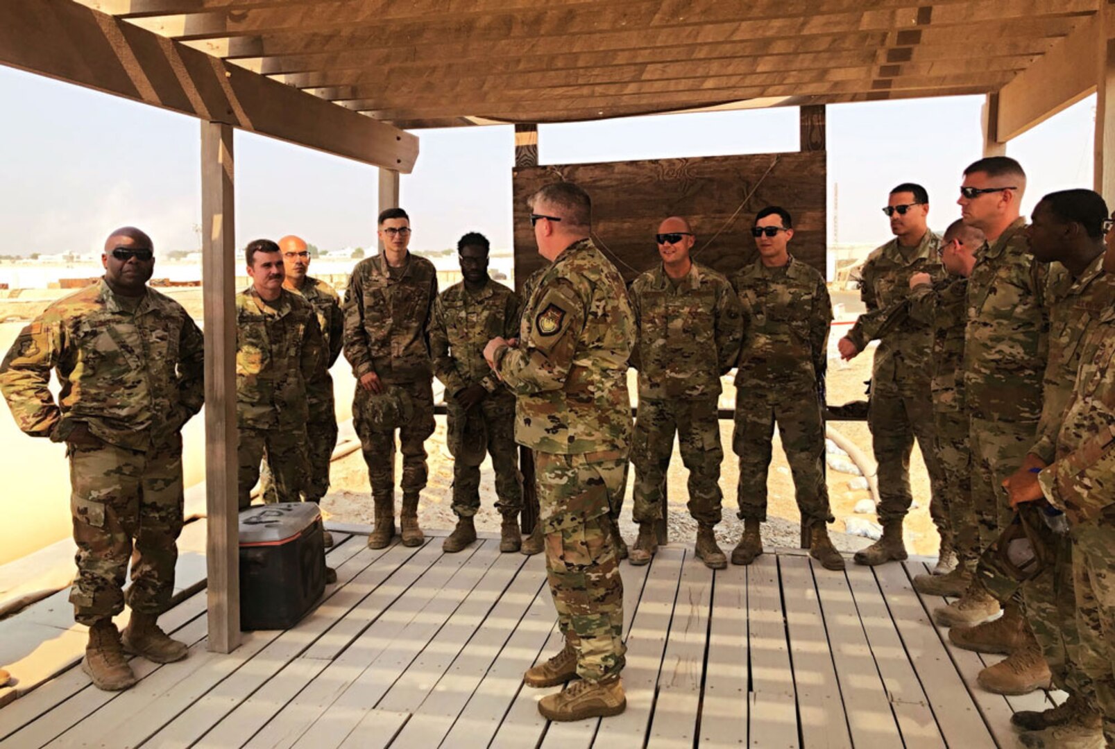 Members of the U.S. Air Force 380th Expeditionary Logistics Readiness Squadron Fuels Management Flight listen to Defense Logistics Agency Energy Commander Air Force Brig. Gen. Albert Miller