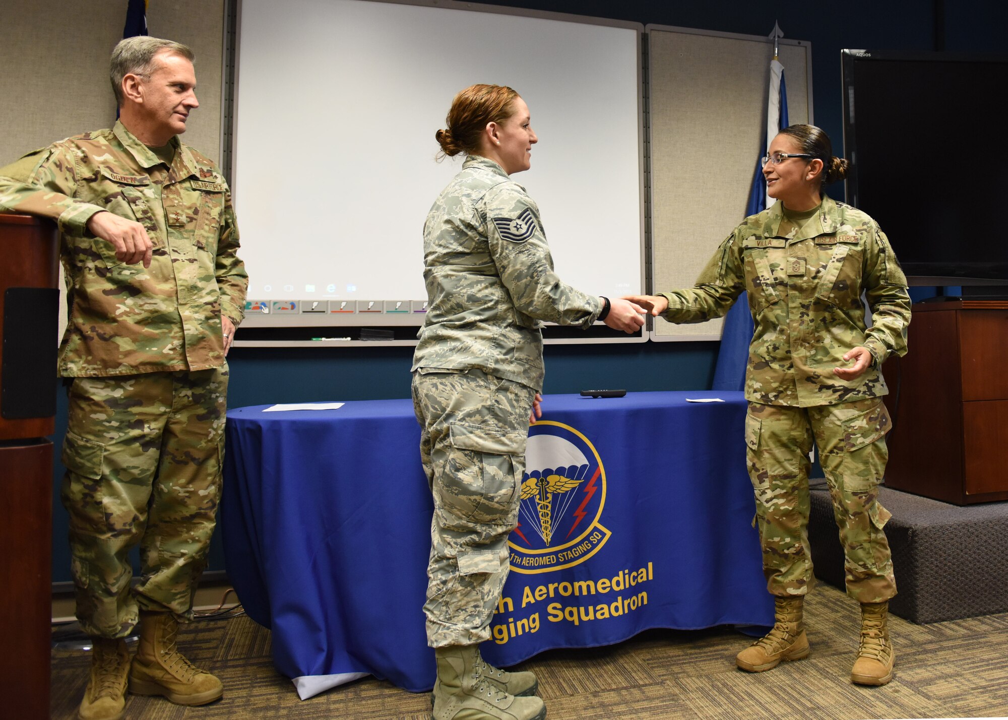 Tech. Sgt. Marissa Patton, 911th Aeromedical Staging Squadron medical administration specialist, receives a challenge coin from Chief Master Sgt. Cynthia Villa, 4th Air Force command chief, and Maj. Gen. Randall A. Ogden 4th AF commander, at the Pittsburgh International Airport Air Reserve Station, Pennsylvania, Nov. 3, 2019.